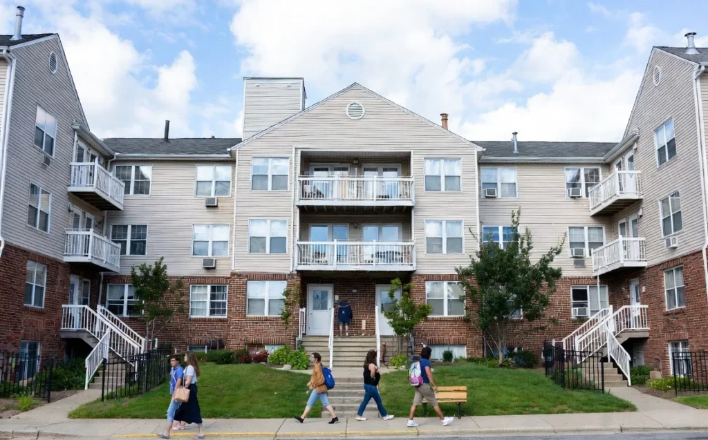 Multifamily apartment buildings with people walking along the street in an urban neighborhood